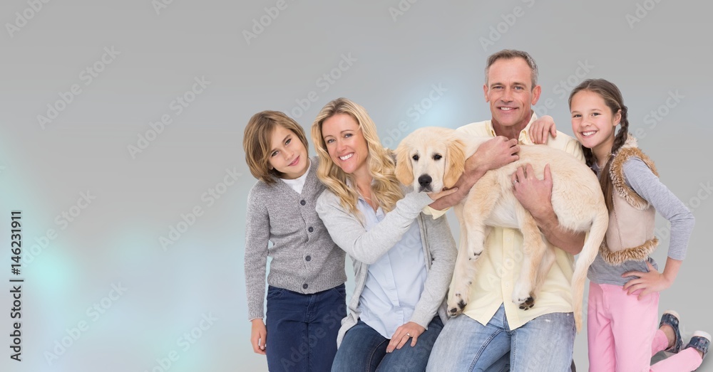 Portrait of happy family with dog against gray background