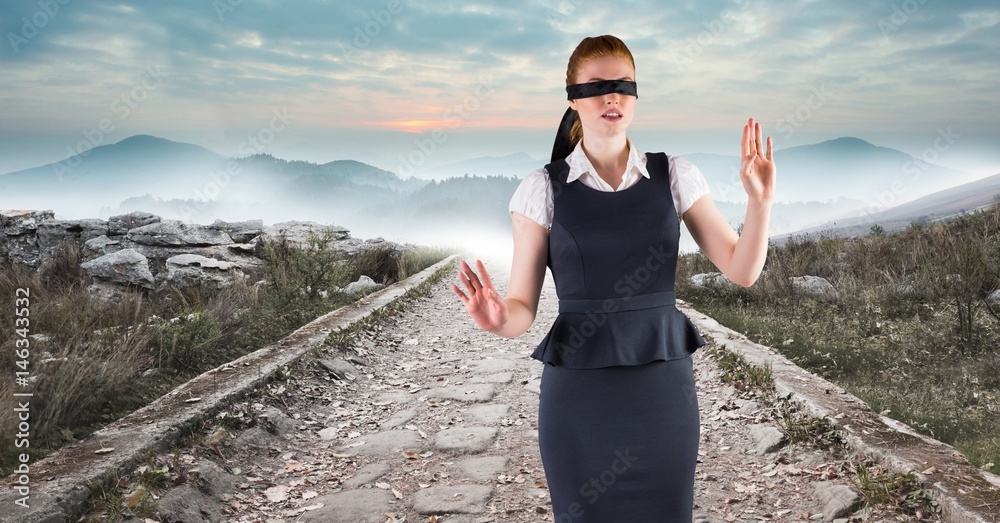 Business woman blindfolded walking down road