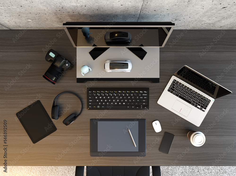 Top view of graphic designer desktop with laptop, digital graphic tablet, DSLR camera, wireless head