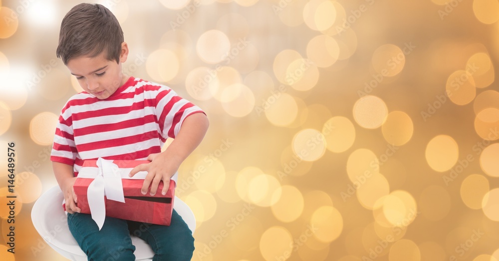 Little boy opening gift box over bokeh