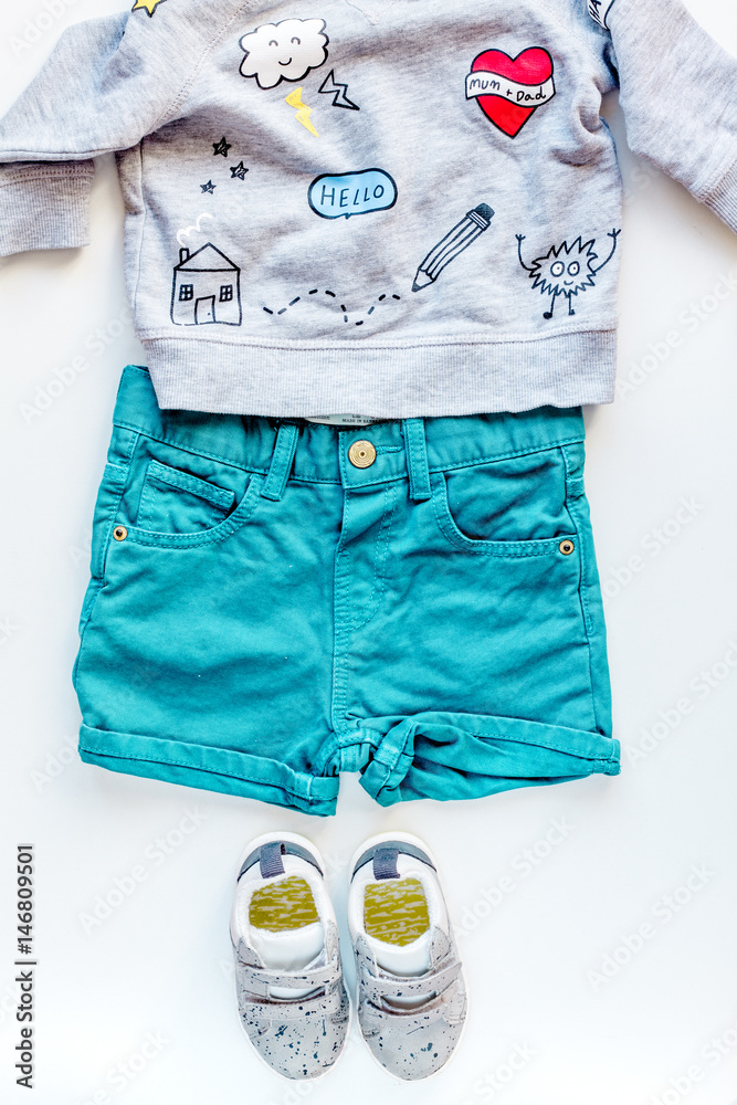 children flat lay with clothes white background top view