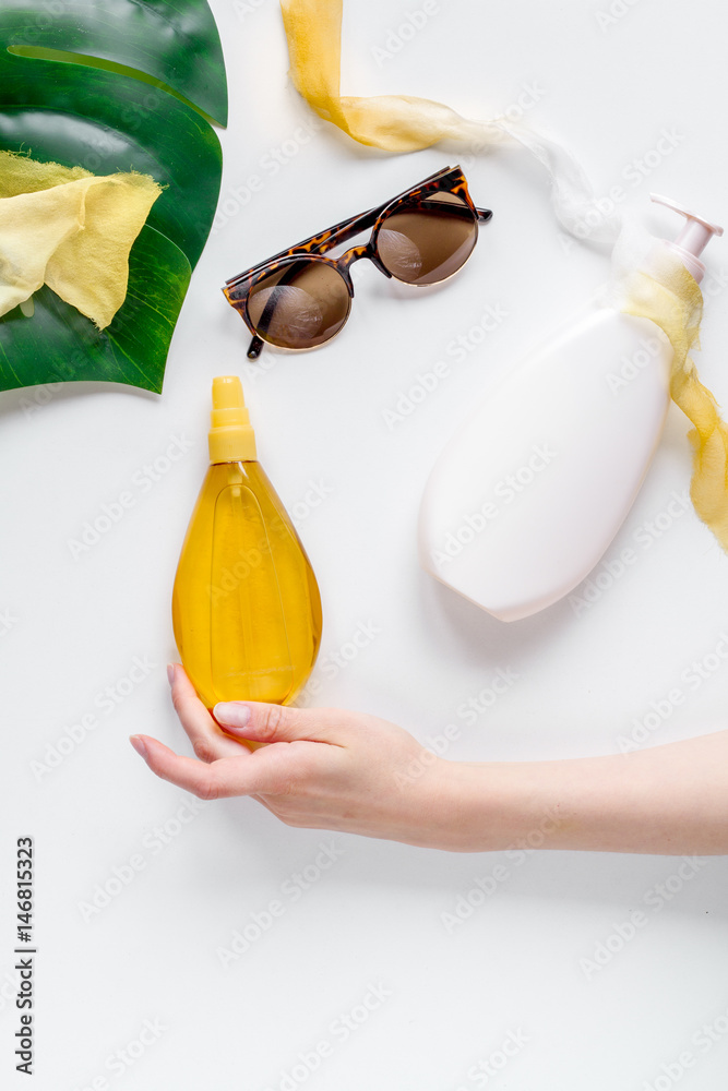 Cosmetic bottle with cream on white background top view