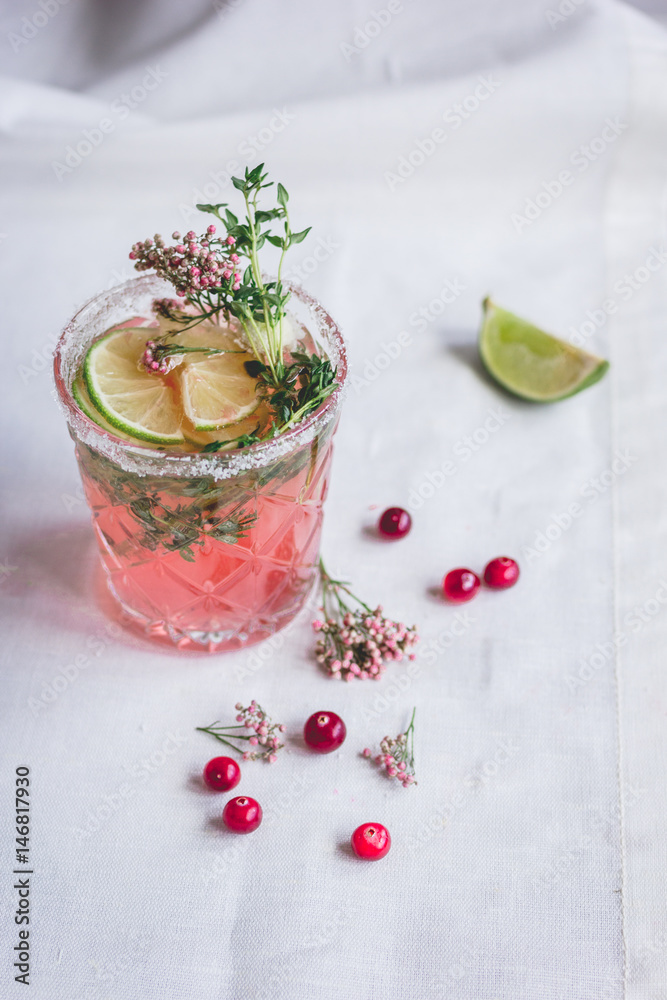 making cocktails in glasses with lime and berries on stone kitchen desk background