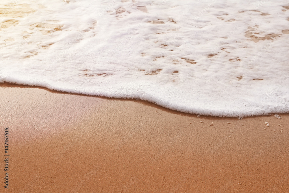 Background. White wave on the sand. Toned photo.