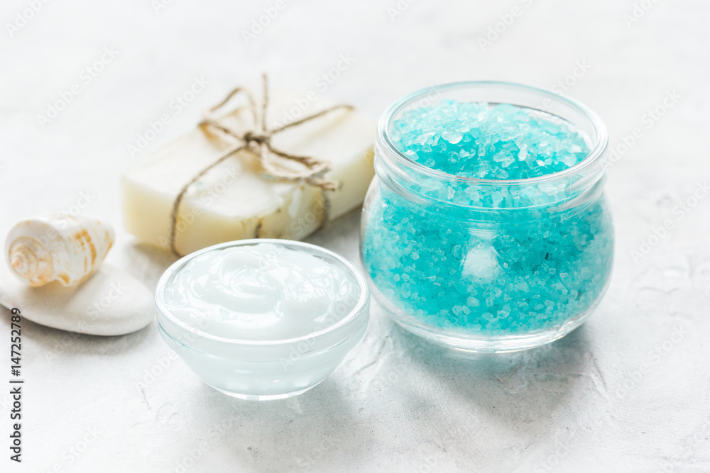 blue sea salt, soap and body cream on stone desk background