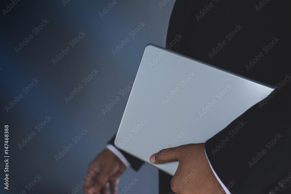 Part of Businessman in Black suit bring digital tablet, New gadget for modern business work concept,