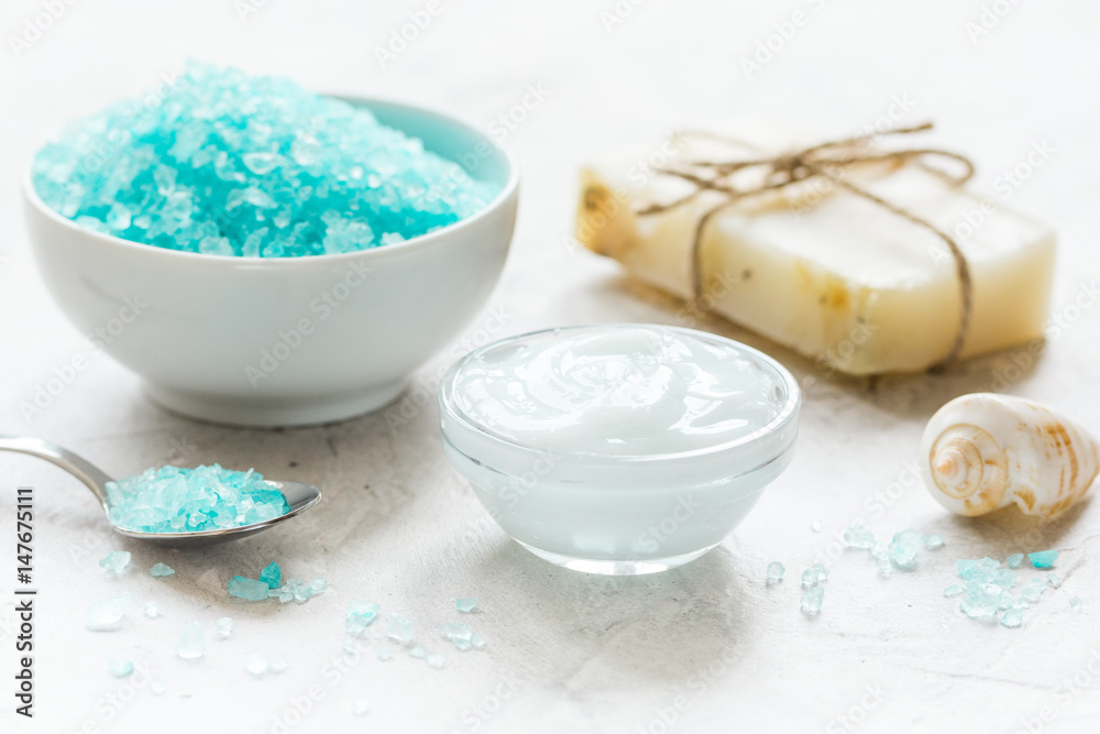 set for bath with blue salt and shells on stone table background