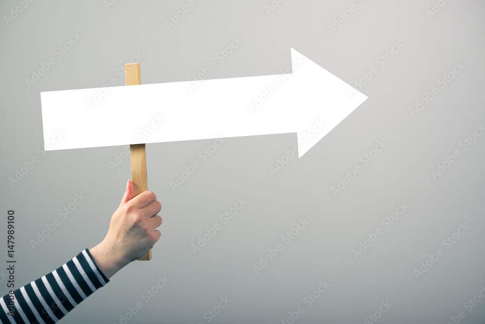 Woman holding guiding direction arrow sign