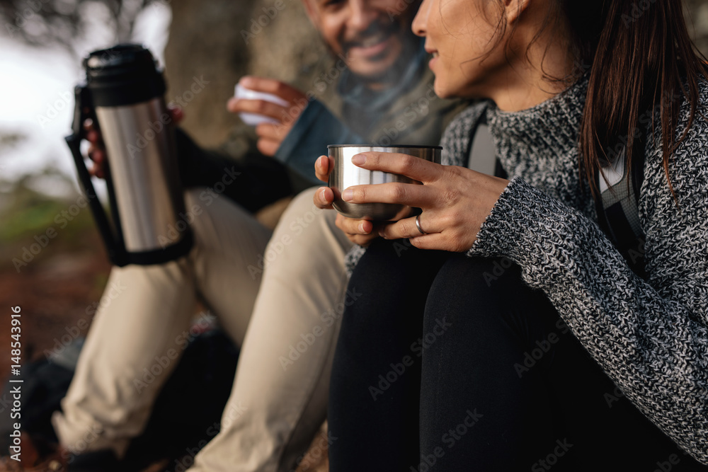 Couple hiking talking rest and drinking coffee