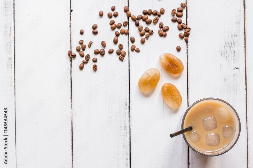 cold coffee glass with ice cubes on white table background top view