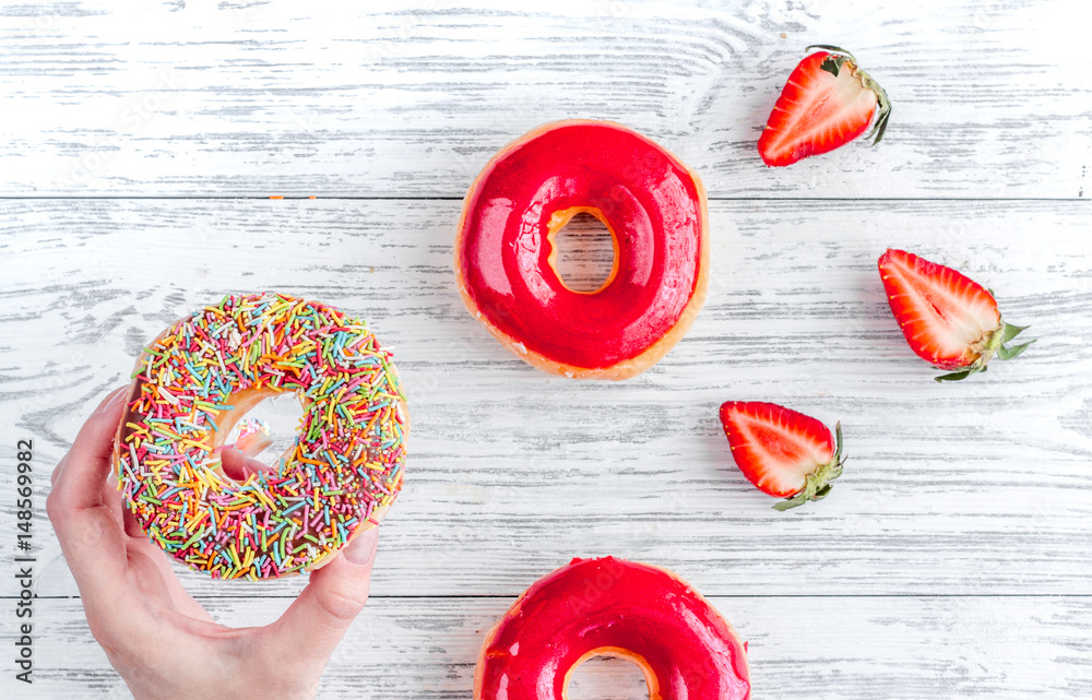 lunch with donuts and strawberry on wooden table background top view