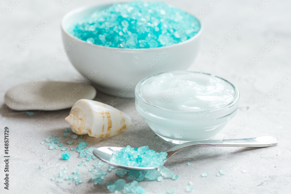 Home cosmetic with cream and blue sea salt on stone background