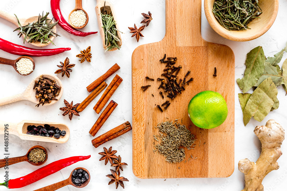 Spices, chili and herbs on white kitchen table background top view