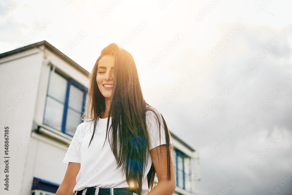 Happy young woman walking past building