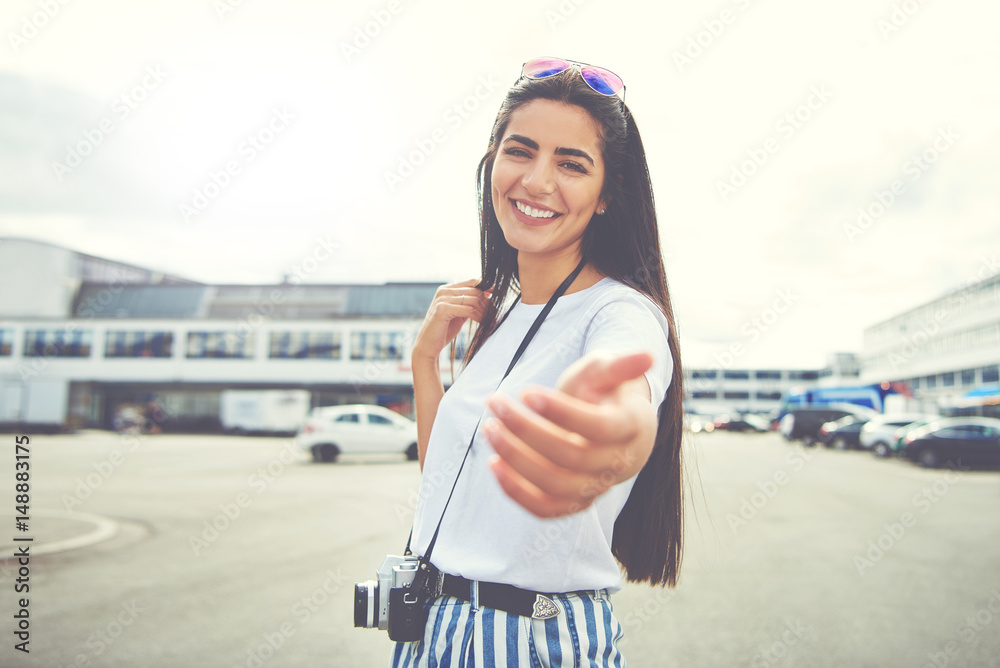 Cute young woman holding out her hand