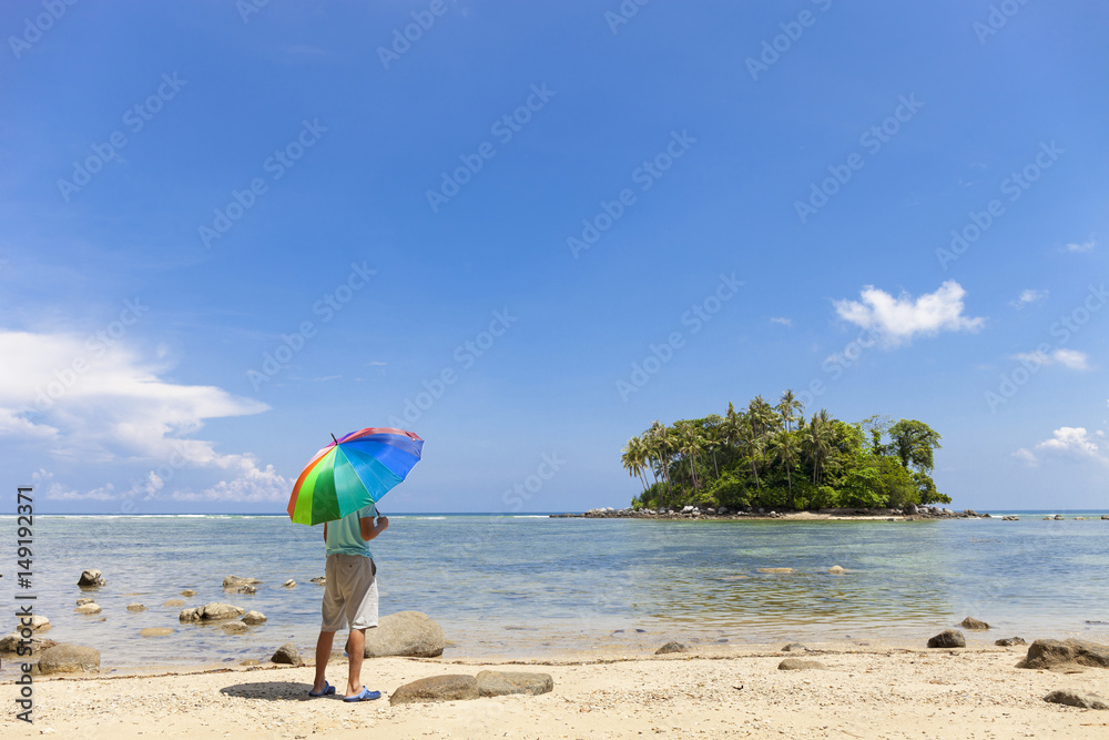 泰国普吉岛沙景岛上带着五颜六色雨伞的旅游者。