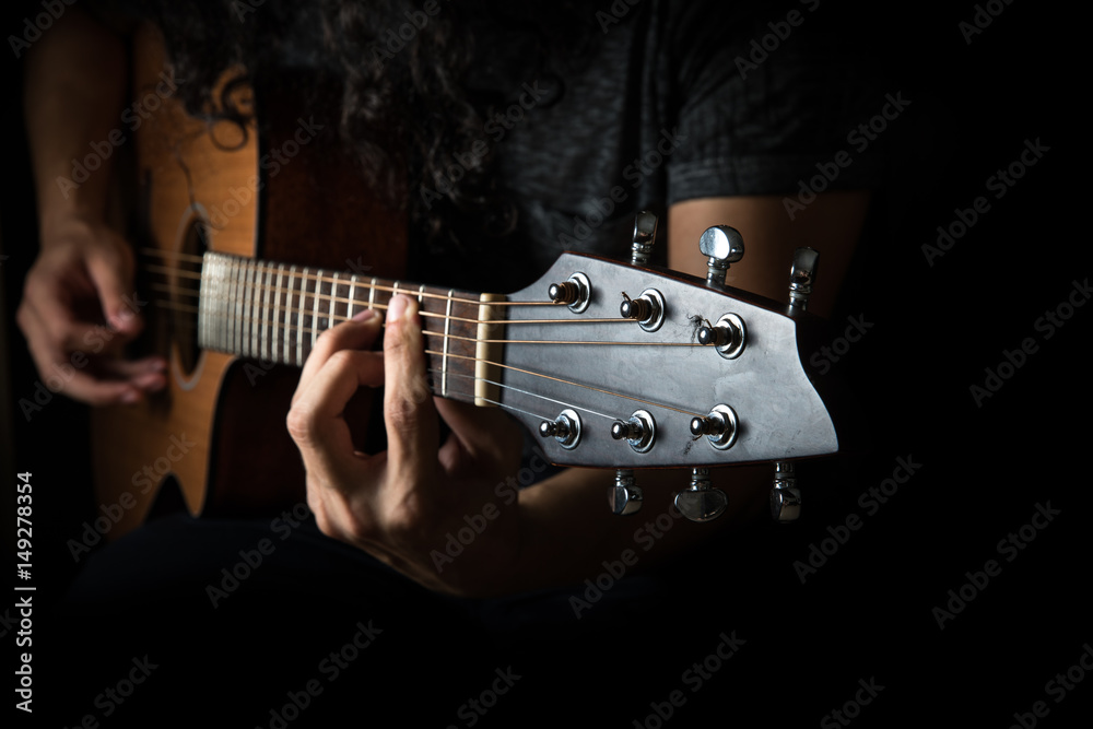 Young man playing a guitar.