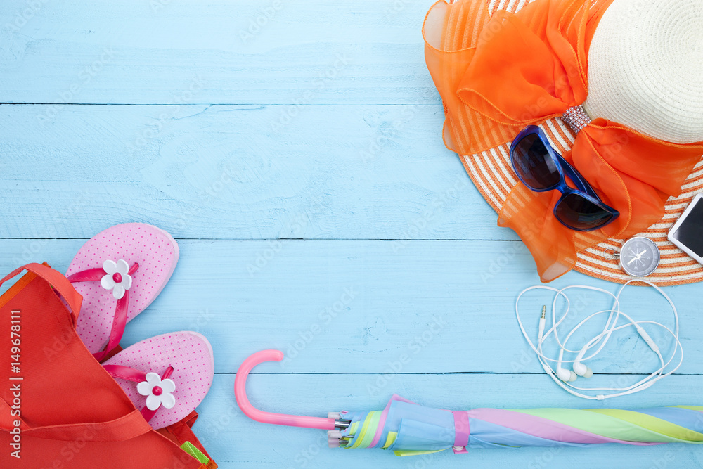 Beach accessory,sunglasses, beach hat,flip-flops,umbrella, compass,music player,earphone on wooden b