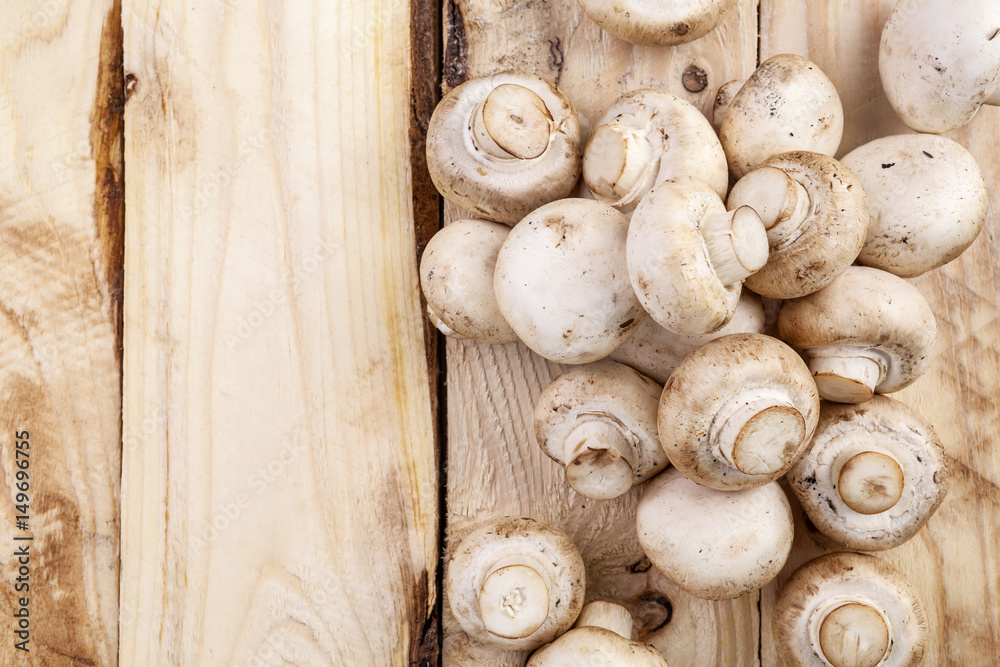 Mushrooms champignon on wooden table. Top view. Copy space.