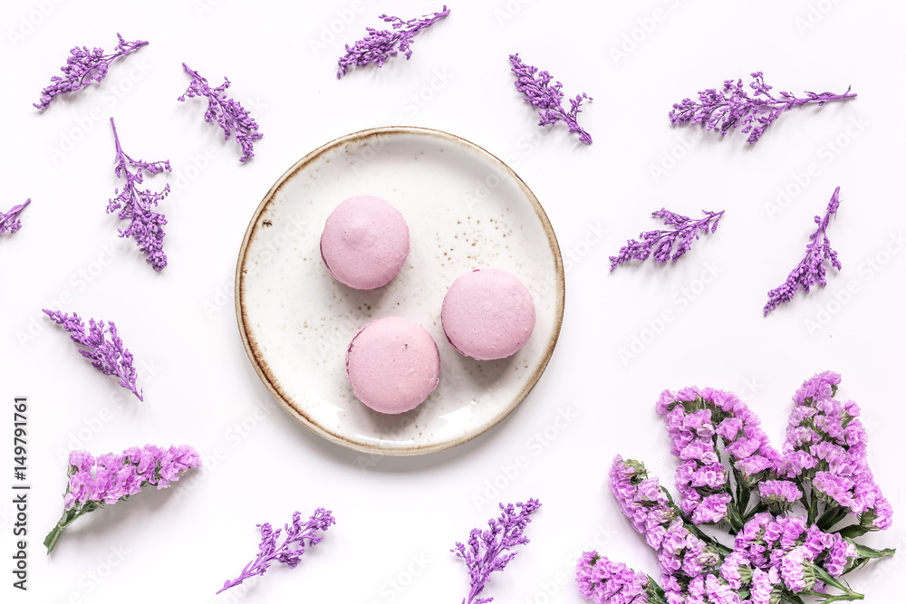 lady morning with macaroons and mauve flowers white desk background top view pattern