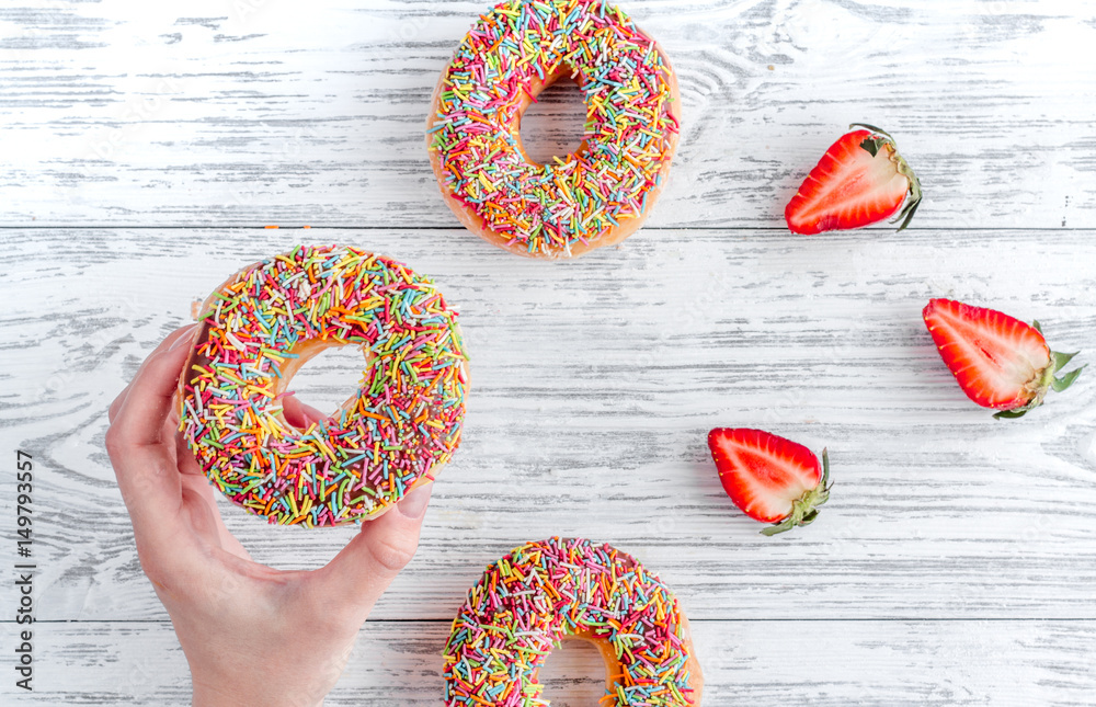 strawberry and chocolate donuts flat lay on wooden background top view