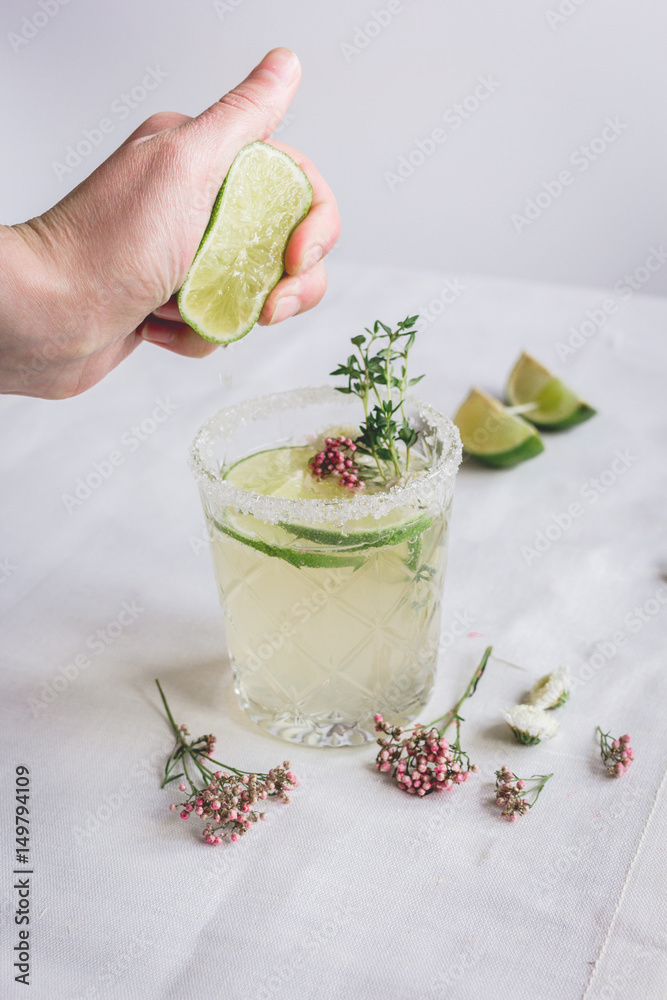 fresh homemade drink with flowers and lime on kitchen background