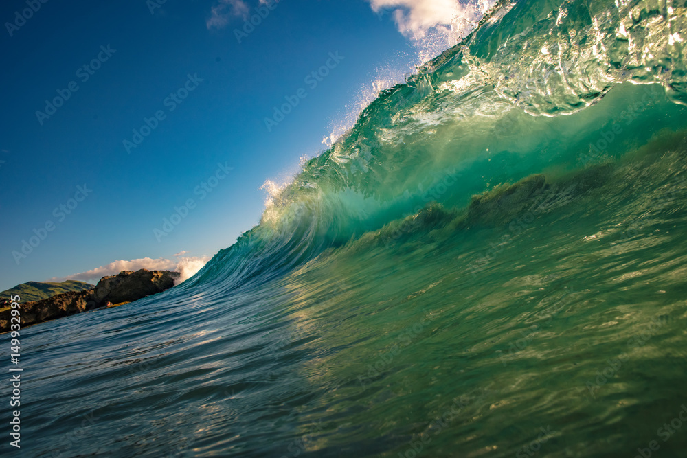 Ocean Wave barreled. Surfing sport activity in tropical water. Blue and green colors on background.