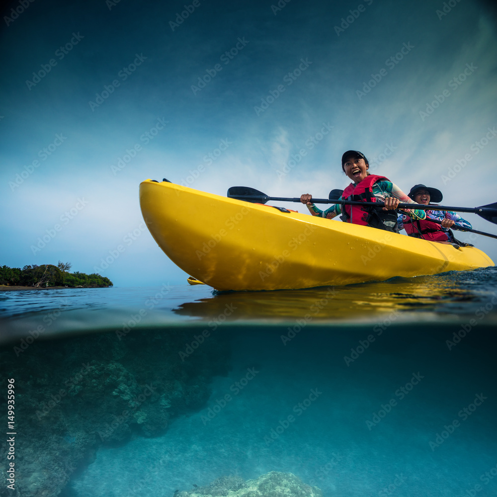 Two smiling girls paddling kayak