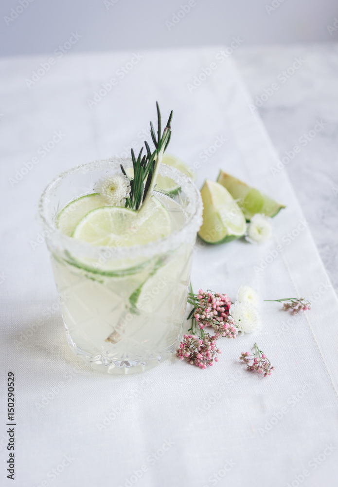 natural cocktail with herbs and cut lime on stone desk background