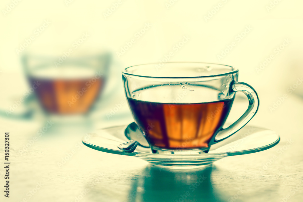 Close up warm the black tea cup on the wooden table in living room , relax with tea time concept