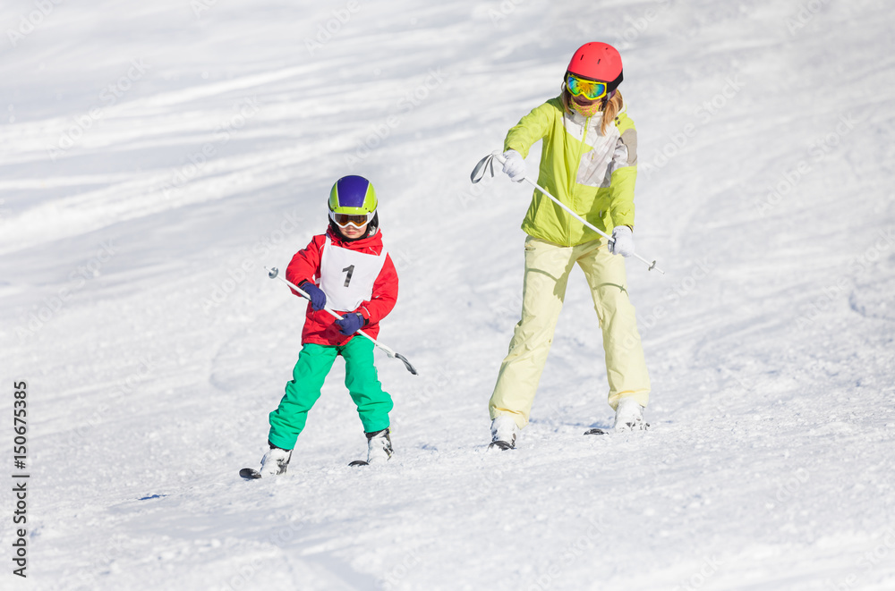 小男孩与女教练一起训练滑雪