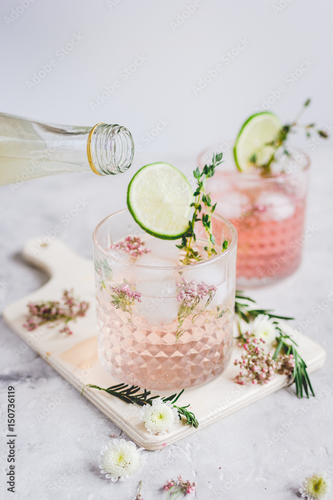 making cocktails in glasses with lime and herbs on stone kitchen desk background