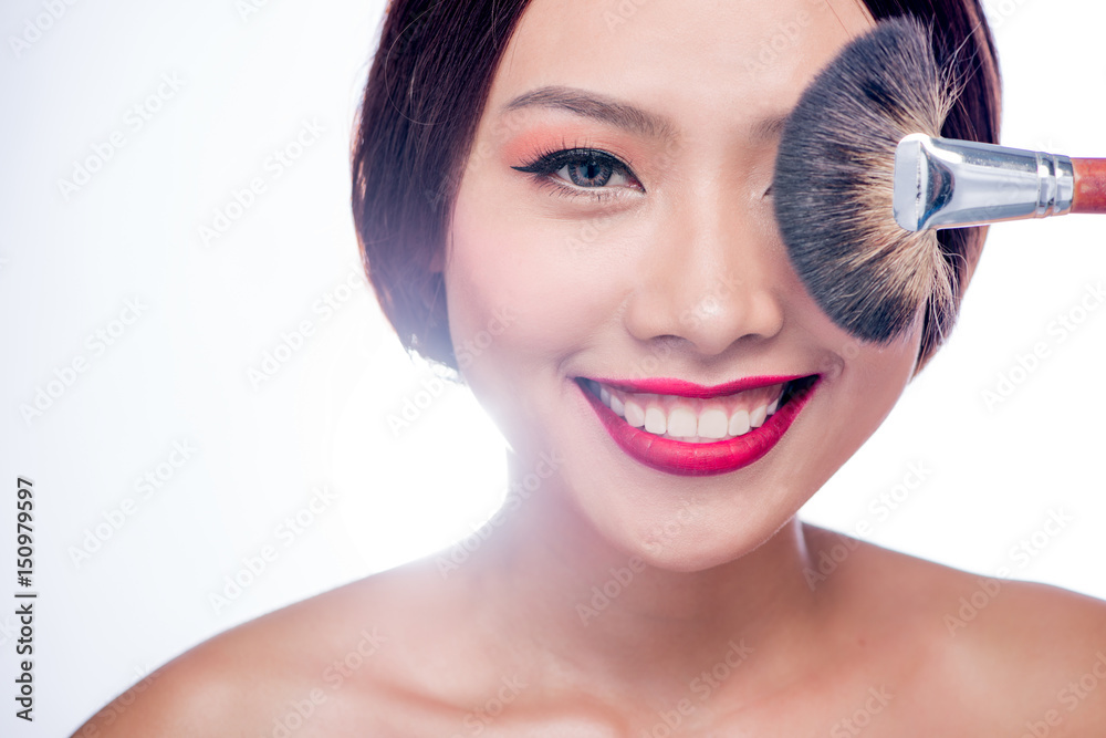 Beautiful asian woman face with perfect makeup  applying dry cosmetic.