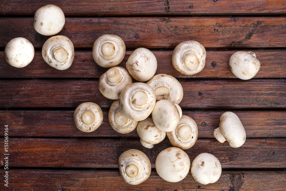 Mushrooms champignon on wooden background. Top view. Copy space.