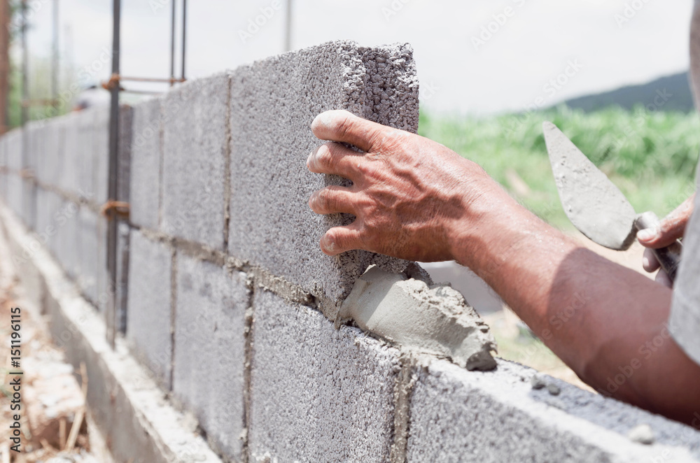 bricklayer installing bricks Masonry work in construction site