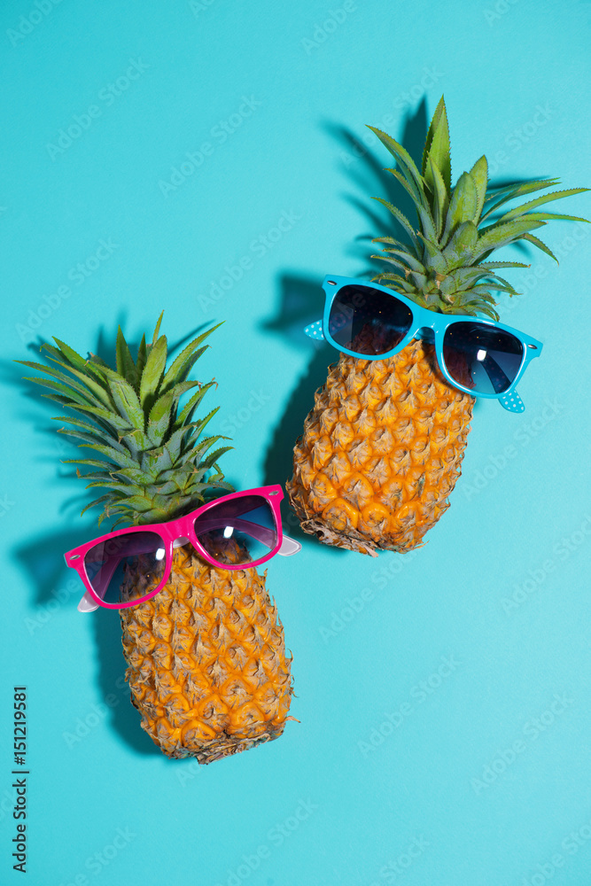 Funny pineapple in a sunglasses over blue background