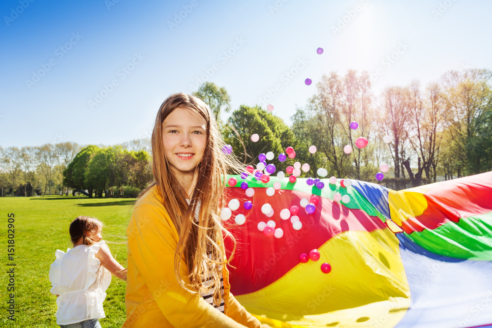 Beautiful girl playing parachute game with friends