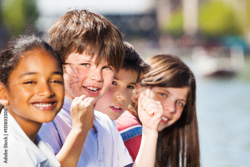 Four smiling kids spending holidays outdoors