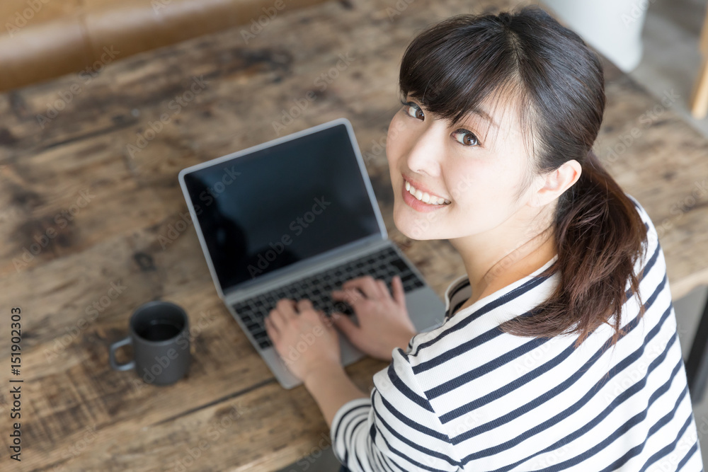 young asian woman using laptop in cafe