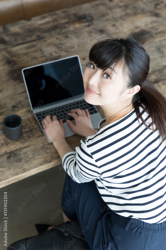 young asian woman using laptop in cafe