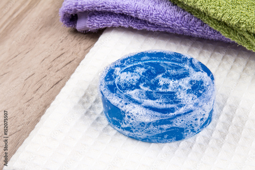 natural soap bar and bubble with bath towel on wooden background