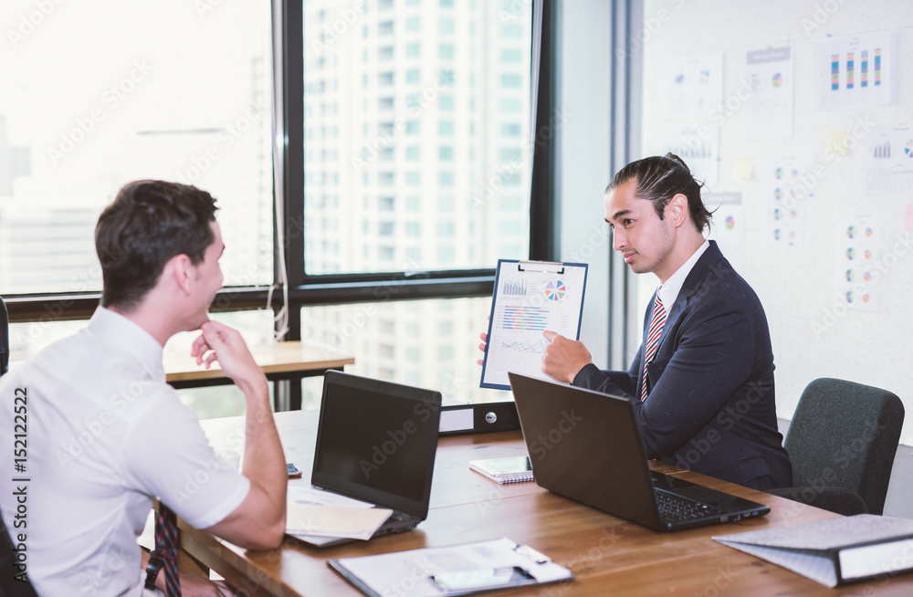 Image of two young businessmen discussing project at meeting.Business presentation. focus on Man wea