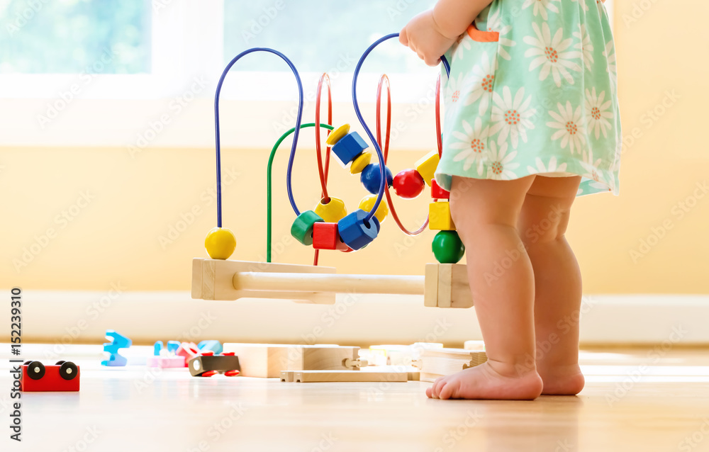 Toddler girl playing with colorful toys