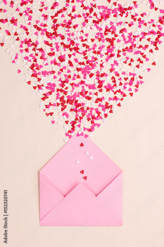 Sweets sugar candy hearts on envelope over green background