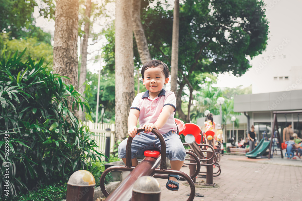 Cute little asian boy in a park on a nice day outdoors