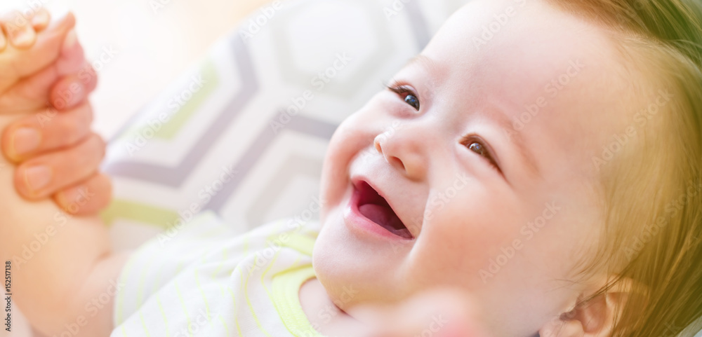 Happy baby boy playing with his parent