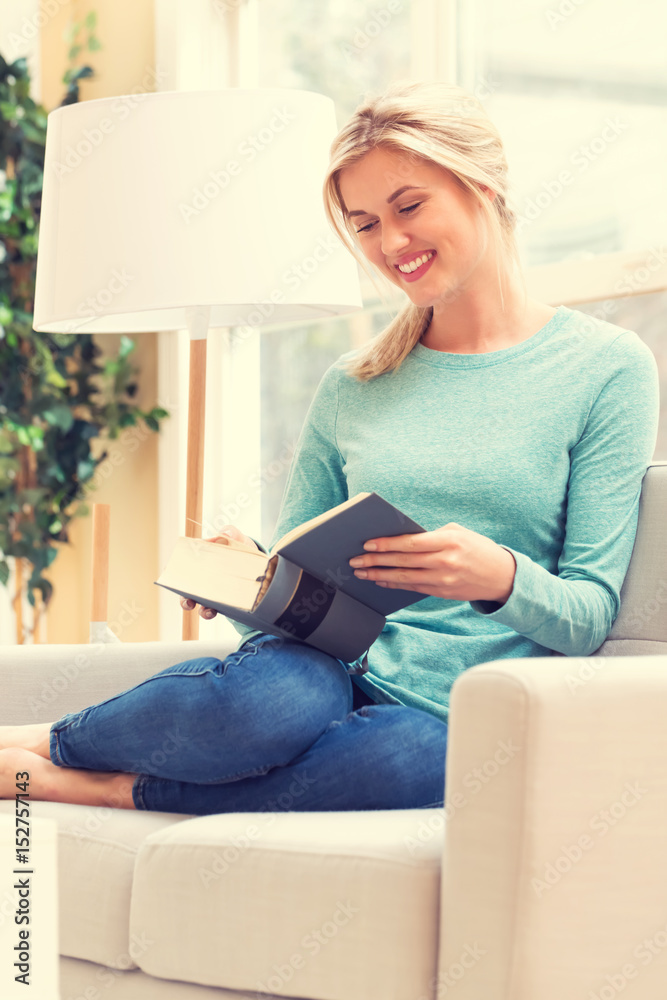 Happy young woman reading a book