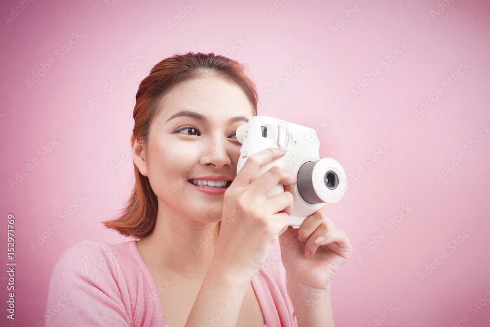 Young woman taking a photo with a camera.