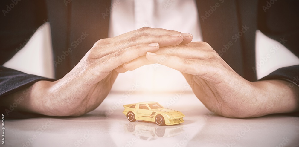 Businesswoman protecting toy car