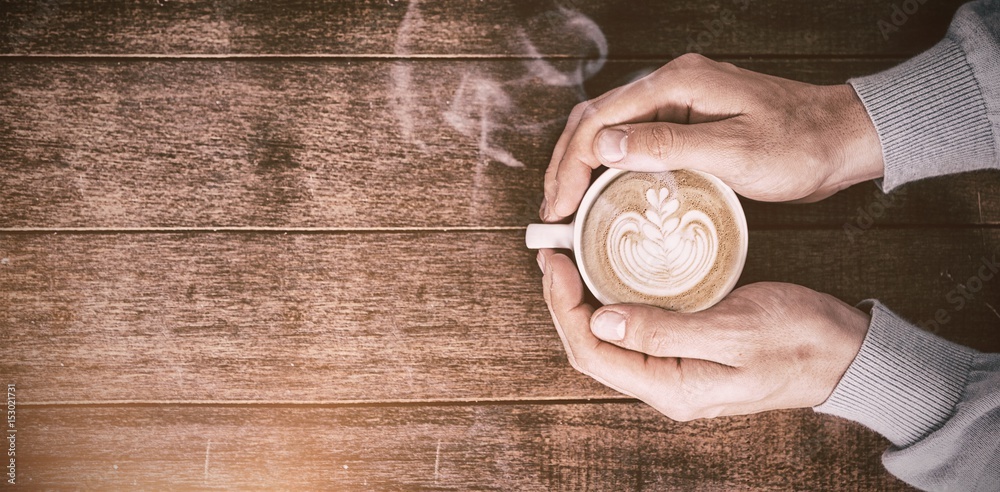 Man holding white coffee cup